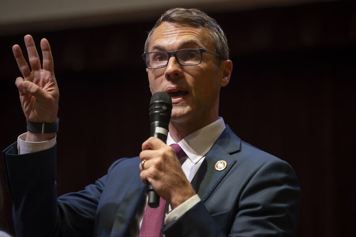 Politician speaking at event holding microphone, representing Democrats narrowing gap in House after Virginia victory.