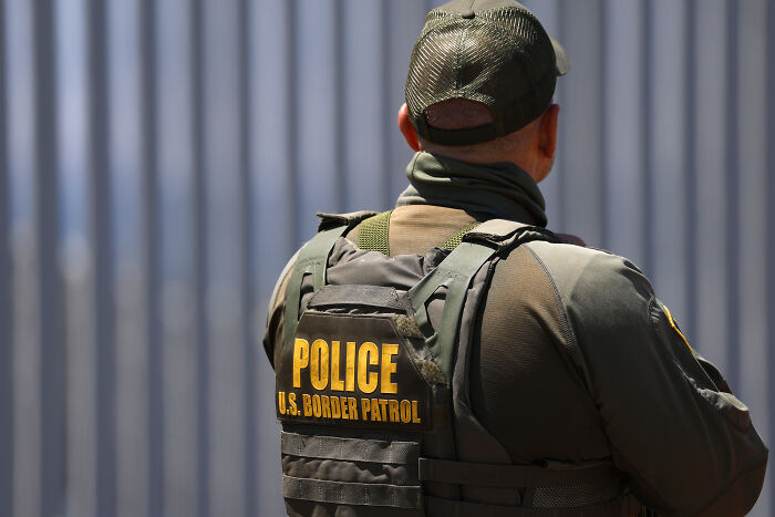 U.S. Border Patrol officer seen from behind, related to dramatic footage of ICE detaining autistic girl to draw dad out.