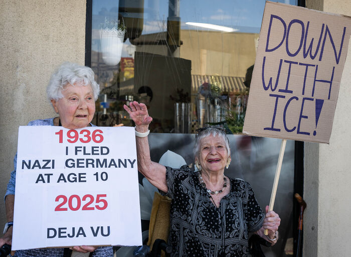 Two elderly women holding protest signs opposing ICE, highlighting a historical and political message about immigration issues.