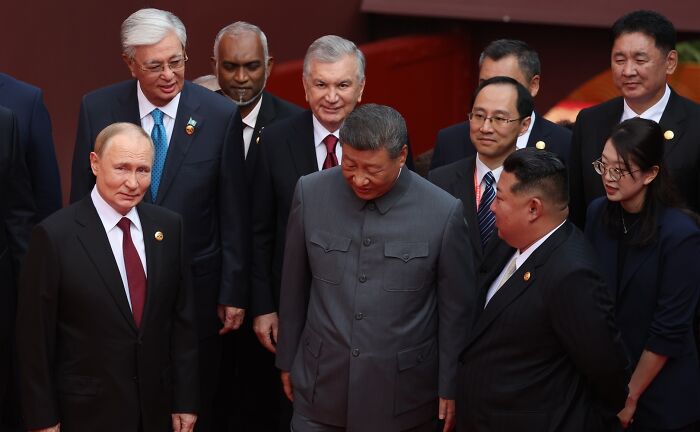 Leaders Putin, Xi, and Kim gathered at an event, relating to claims of conspiring against the U.S. and paranoia concerns.