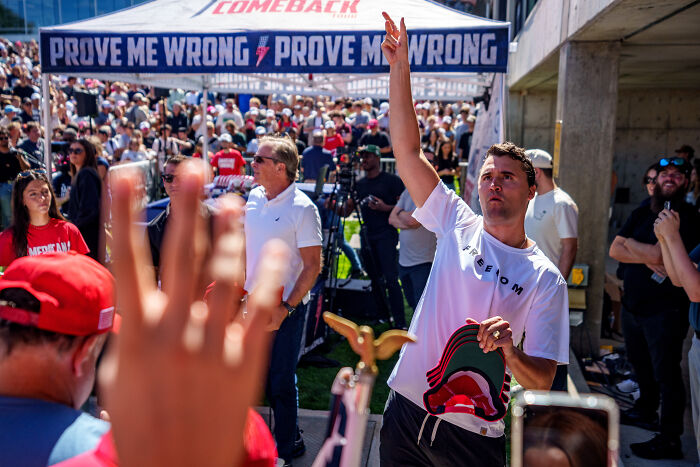 Crowd gathered at a rally with a man raising his hand, related to ABC News reporter and texts from Tyler Robinson controversy.