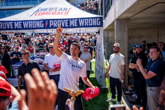 Crowd gathered under a tent with Prove Me Wrong signs during a political rally related to Karoline Leavitt Utah quake claims.