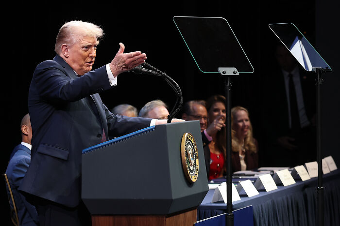 Donald Trump speaking at a podium with presidential seal, comments on domestic violence sparking fierce backlash.
