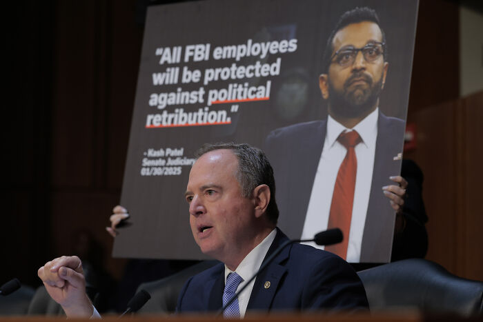 Adam Schiff speaking at a hearing with a Kash Patel poster about political retribution in the Epstein files case.