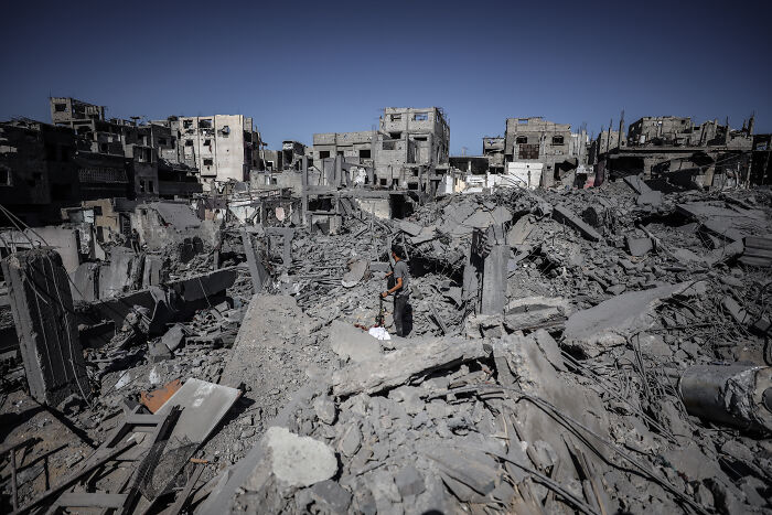 Man standing amid rubble with damaged buildings in the background, symbolizing Benjamin Netanyahu snubbed at UN General Assembly.