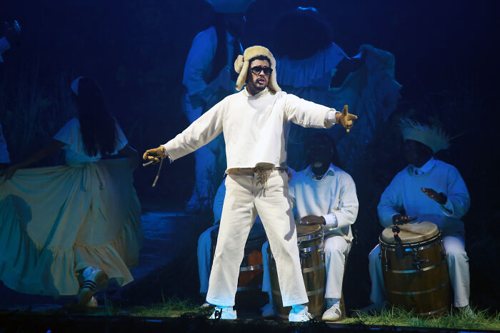 Bad Bunny performing in white outfit with musicians on drums during Super Bowl halftime show triggering MAGA outrage.