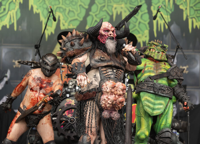 Rock band members in elaborate costumes perform a provocative skit depicting Trump and Musk onstage amid controversy.