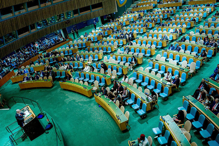 Benjamin Netanyahu speaking at UN General Assembly with many empty seats and few delegates attending the session.