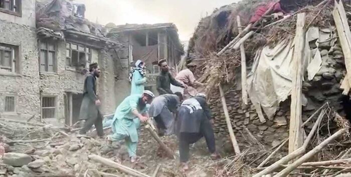 Rescue teams digging through rubble amid destroyed buildings in Afghanistan after a devastating earthquake disaster.