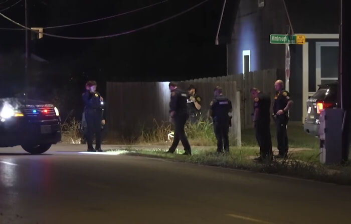 Police officers investigate a nighttime scene in Houston where an 11-year-old boy was fatally shot during a doorbell prank.