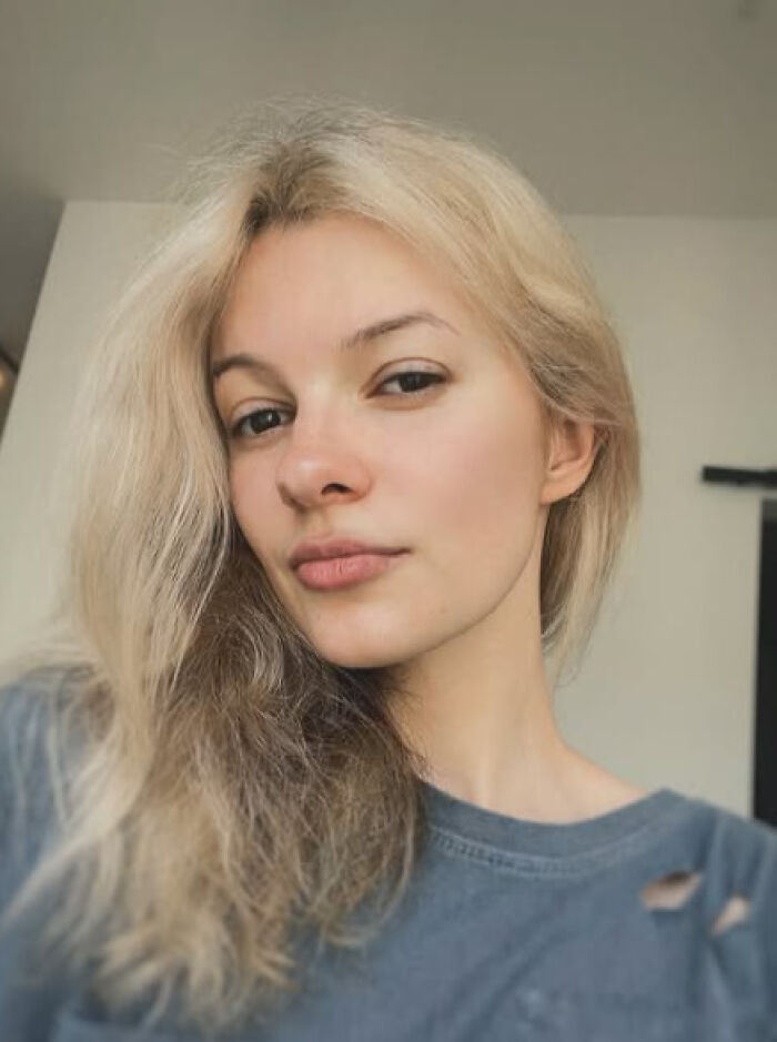 Young woman with blonde hair wearing a faded blue shirt, representing story of suspected Ukrainian refugee attacker speaking from jail.