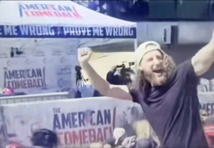 Crowd gathers under American Comeback banners as left-wing hashtag activists celebrate Charlie Kirk assassination claims.