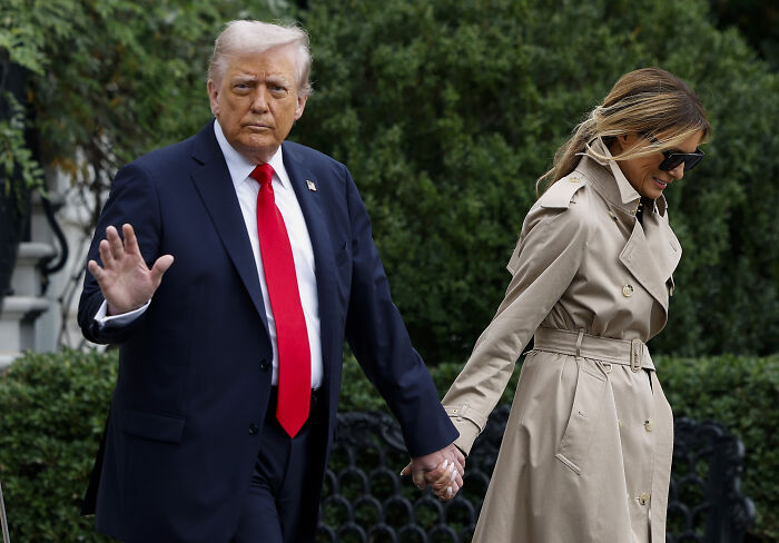 Donald Trump and Melania holding hands as she conceals his injury with a strategically-placed hand during UK arrival.