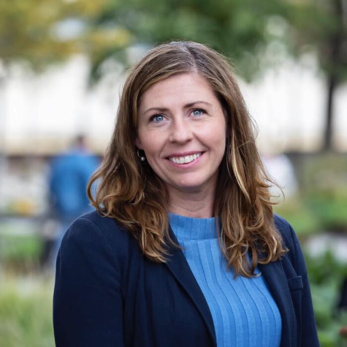 Sweden&rsquo;s new health minister outdoors, smiling with shoulder-length hair, wearing a blue top and dark blazer in natural setting