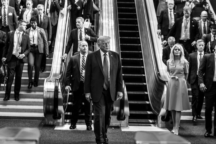 Donald Trump walking down stairs with security and staff, relating to Trump and Bibi visiting the Knesset event.