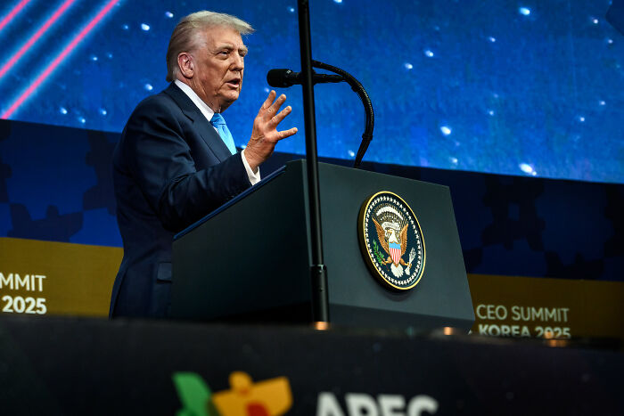 Former president speaking at a podium with presidential seal, addressing audience at APEC CEO Summit 2025.