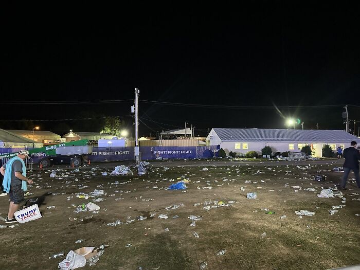 Nighttime scene showing trash scattered across a field after a Trump rally, highlighting difference from No Kings protests.