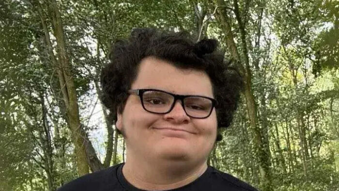 Young man wearing glasses outdoors with trees in the background related to mom sedated son case.