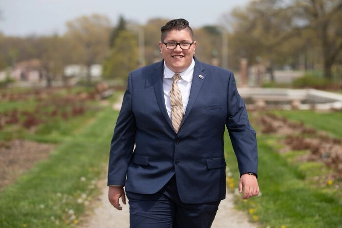 Young Republican leader in a navy suit walking outdoors, associated with racist remarks in a private chat report.