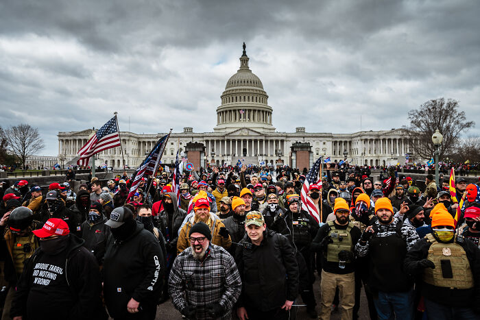 Crowd outside US Capitol on January 6 with flags and hats, related to prosecutors called mob of rioters placed on leave by DOJ