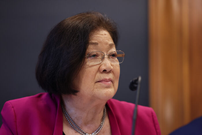 Bondi wearing glasses and a magenta blazer, dodging questions about alleged Trump photos linked to Epstein investigation.
