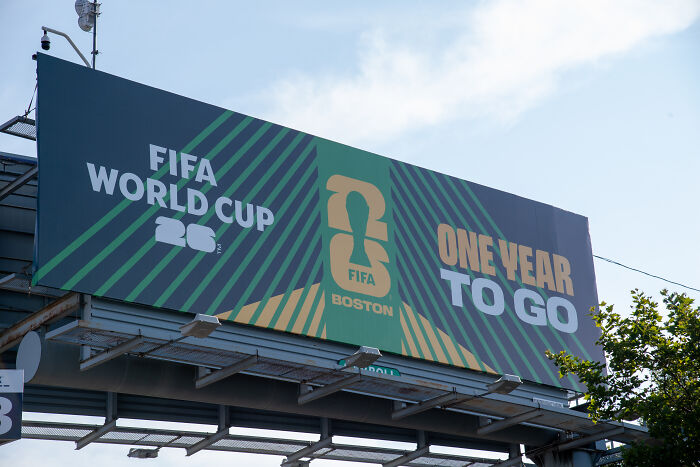 Billboard in Boston showing FIFA World Cup 2026 countdown with one year to go amid World Cup games pull threats.