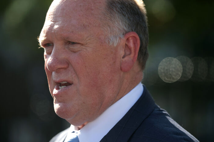 JD Vance outdoors in a suit, appearing frustrated during an interview, capturing his reaction to being cut off mid-sentence.