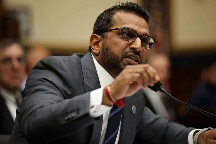 Man in glasses and suit speaking into a microphone during a hearing on FBI monitoring Republican senators investigation.
