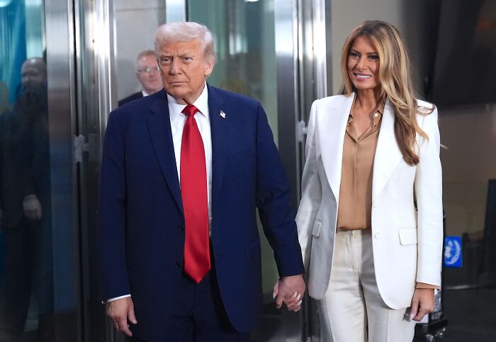 Donald Trump and Melania Trump holding hands, dressed formally, amid divorce allegation discussions by Eric Trump.