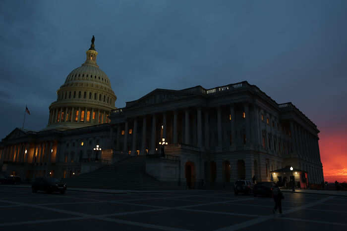 US Capitol building lit at dusk as government shutdown hits nation amid intense political blame game.