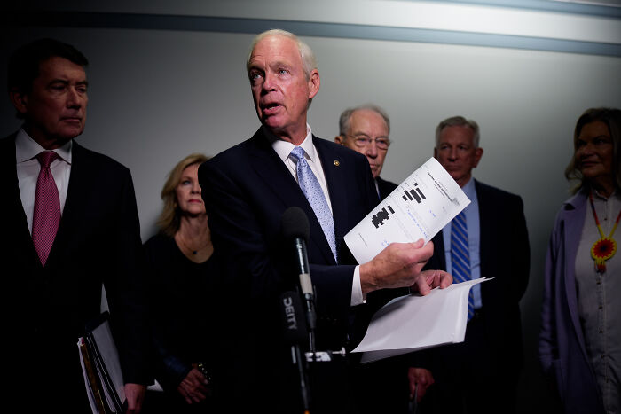 Republican senator speaking at a press conference holding documents during FBI monitoring discussions in January 6 investigation.