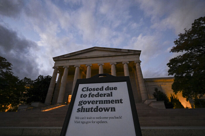 Sign in front of a government building announcing closure due to federal government shutdown during the crisis.