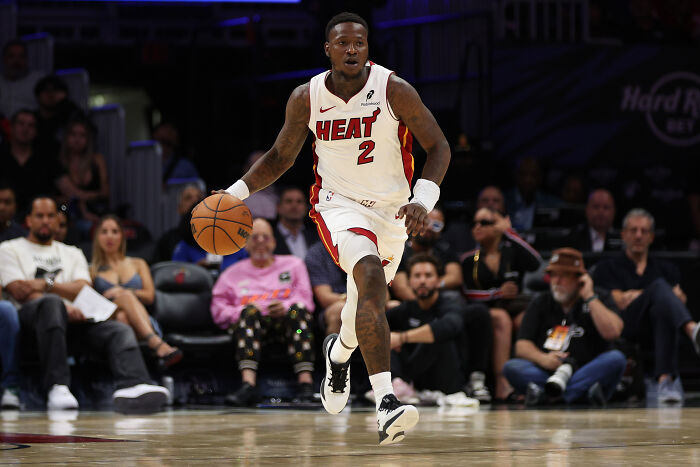 NBA player in Heat uniform dribbling the ball during a game, highlighting insider bets and rigged gambling cases.