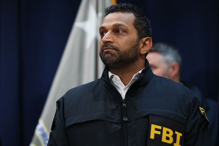FBI agent in a black jacket at a press conference discussing NBA gambling cases involving mafia money and rigged games.