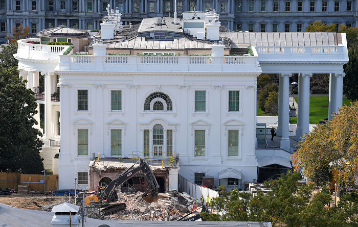 View of White House renovations in progress with construction equipment and workers amid controversy in D.C. projects oversight.