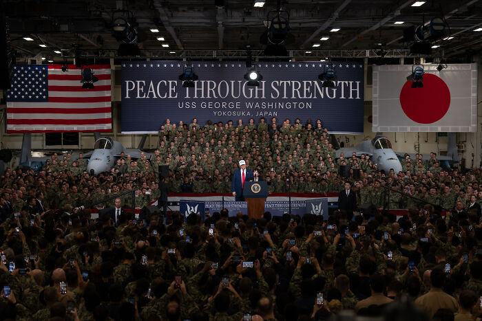 Donald Trump speaking aboard USS George Washington aircraft carrier in front of military personnel during a speech about magnets and steam.