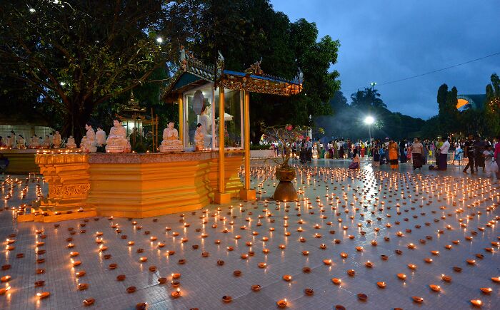 Festival scene with numerous lit candles and people gathered outdoors, unrelated to paraglider drops bombs incident.