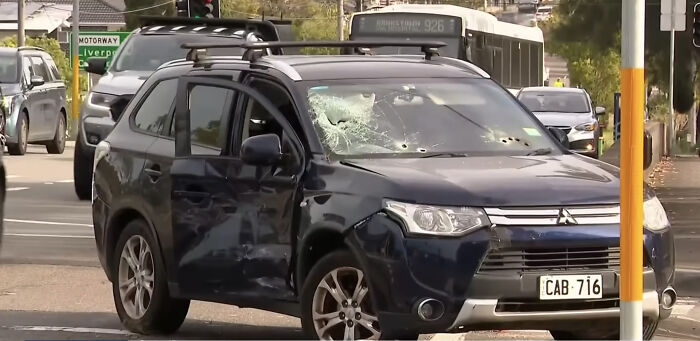 Damaged black SUV intercepted on busy street with shattered windshield and dented door, linked to alleged assassins en route to daycare.