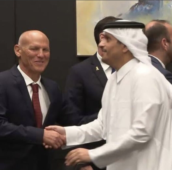Two men shaking hands representing diplomatic talks amid doubts over Israel&rsquo;s ceasefire and Hamas hostage release claims.