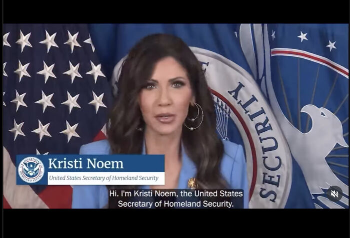 Kristi Noem speaking in front of Homeland Security flag, discussing government shutdown and airport video policies.