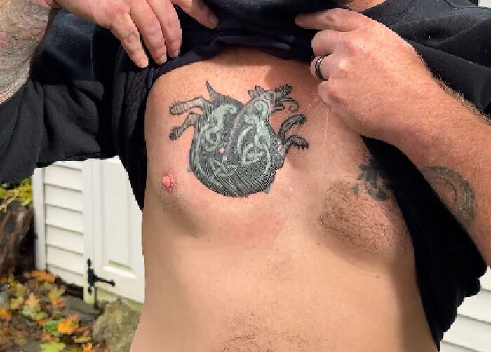 Maine Senate candidate lifts shirt to reveal tattoo partially covered, recognized as hate symbol on chest.