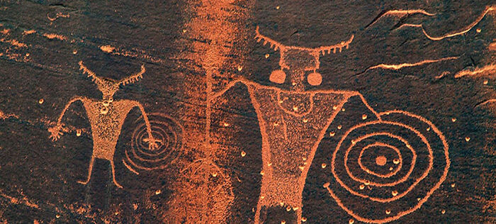 Ancient Hopi petroglyph showing mysterious figures with circular symbols linked to the red cap prophecy transforming the U.S.