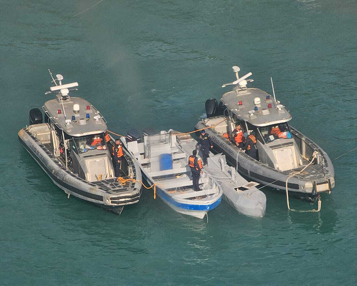 Coast guard personnel on patrol boats and smaller vessels in calm water amid Colombia Venezuela tensions analysis.