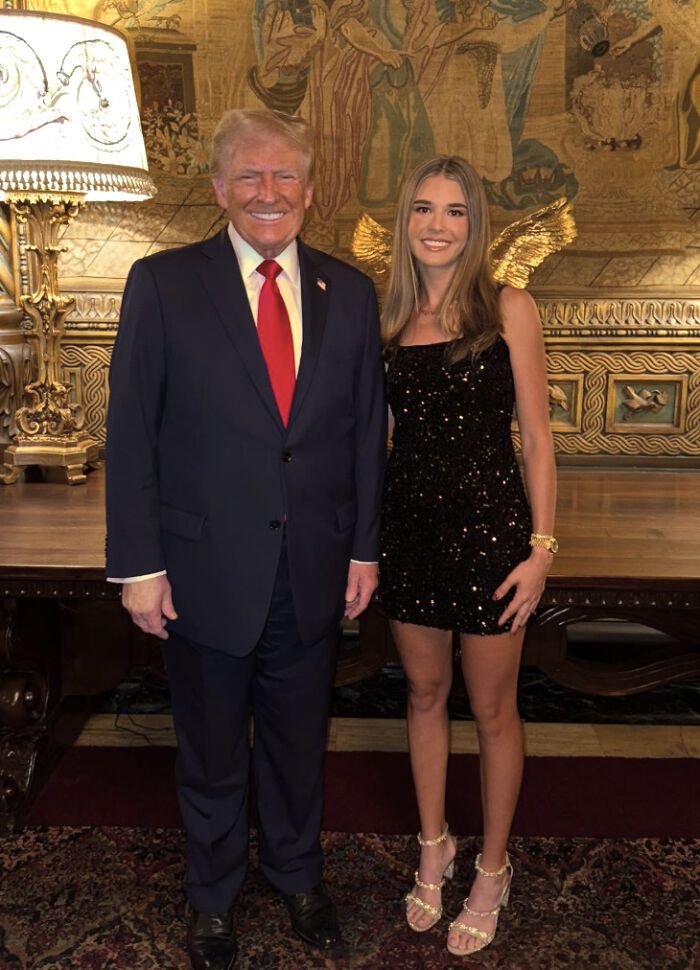 Donald Trump and his granddaughter posing indoors, highlighting Trump&rsquo;s longstanding hand problems revealed unintentionally.