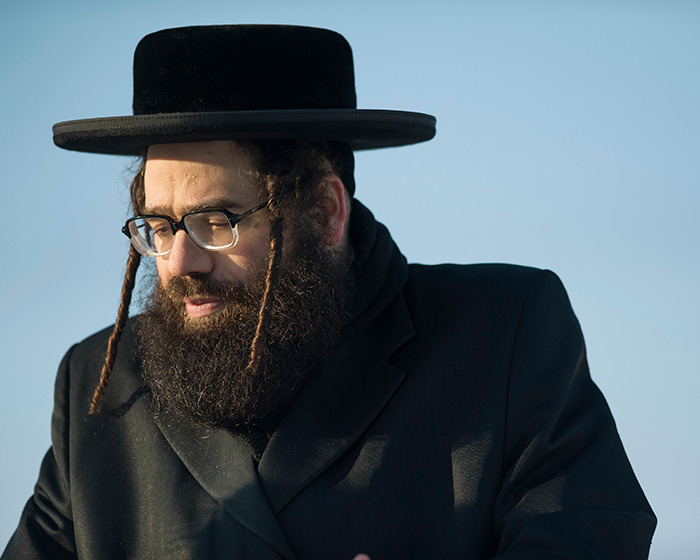 Man with beard and glasses wearing traditional attire representing Lev Tahor sect involved in police rescue of children