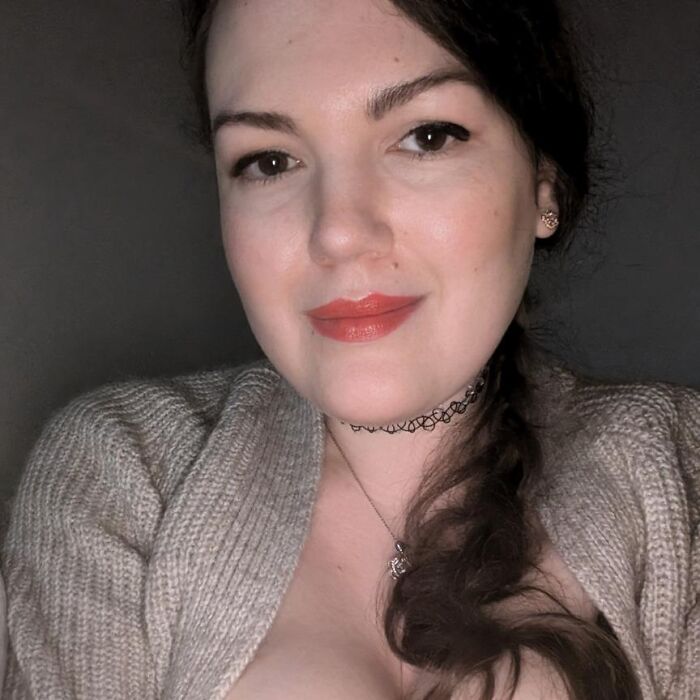 Young woman with dark hair and red lipstick wearing a knitted sweater and choker related to British woman homicide case