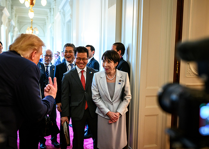 Group of world leaders in a hallway discussing new energy initiatives at a G20 summit event.