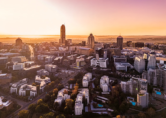 City skyline at sunset with modern buildings representing G20 powers advancing new energy initiatives.