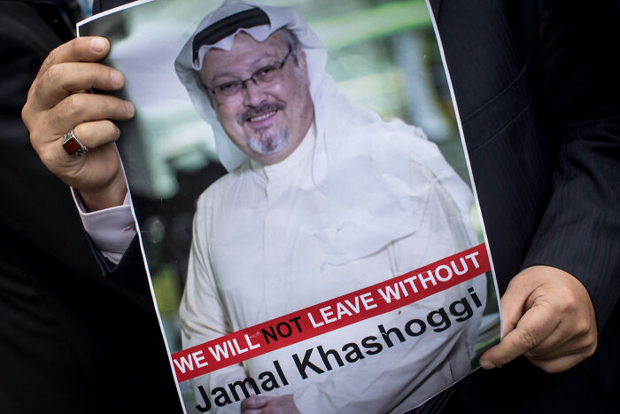 Person holding a poster of Jamal Khashoggi with text referencing a statement, related to Melania Trump&rsquo;s gesture at White House.