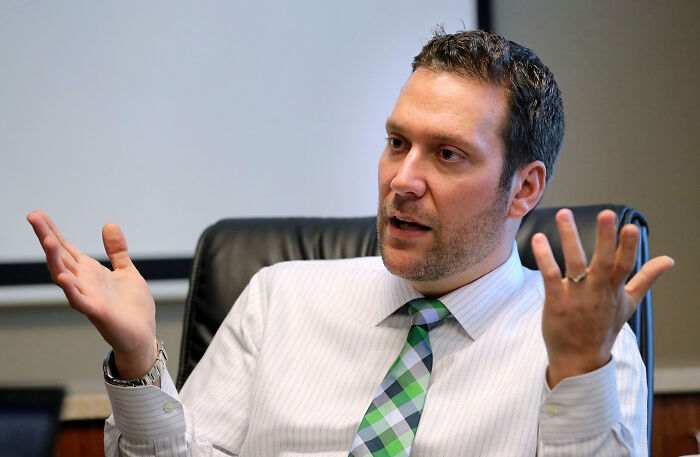 Man in a striped shirt and green plaid tie gesturing while discussing the teen at center of Matt Gaetz probe.